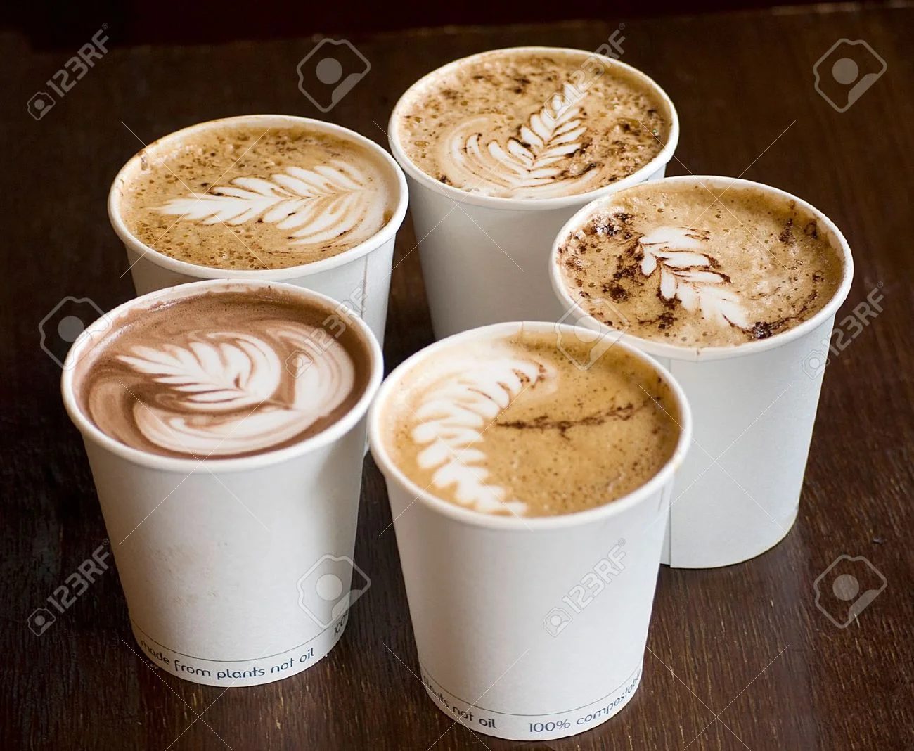 14394075-five-cappuccino-cups-over-wooden-table-Stock-Photo.webp