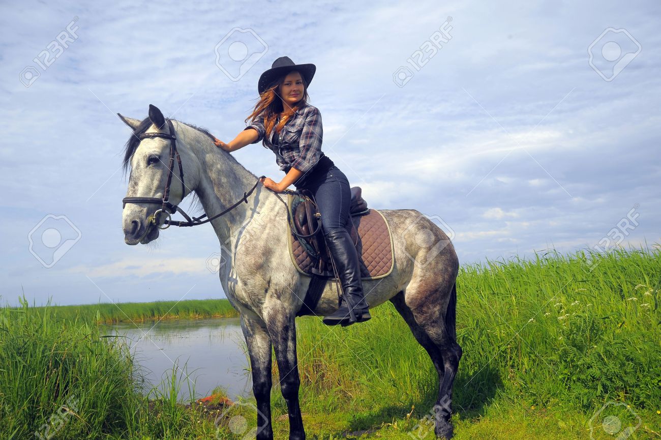 21786362-girl-in-a-cowboy-hat-on-a-horse-Stock-Photo.jpg