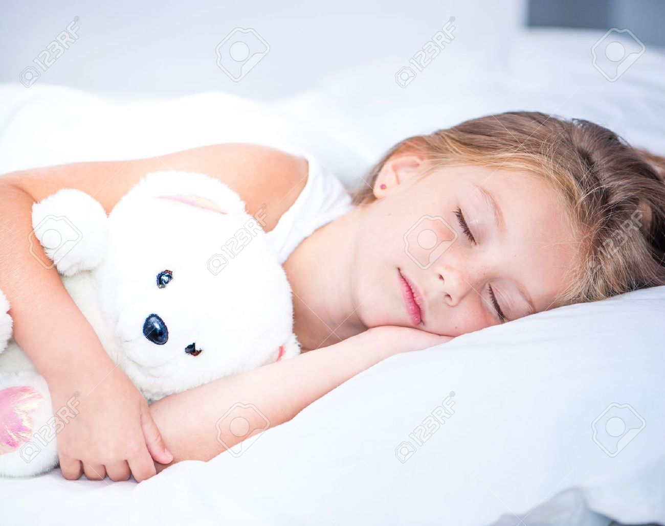 22450266-little-girl-sleeping-in-white-bed-Stock-Photo.jpg