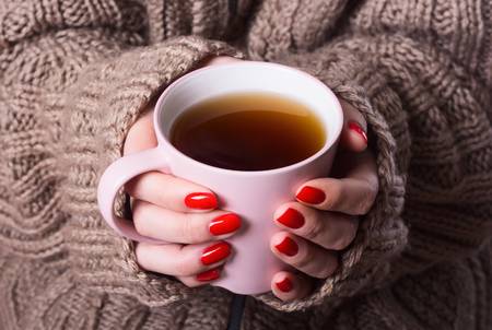 71259495-woman-with-sweater-holding-tea-in-hand.jpg