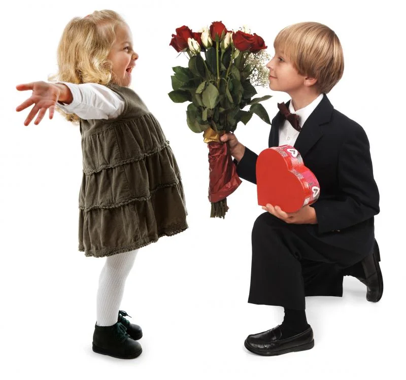 a-little-boy-giving-hearts-and-flowers-to-a-little-girl-on-a-white-background.webp