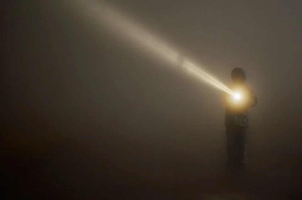 breaking-fog-with-flashlight-on-grouse-mountin-top-960x636.webp