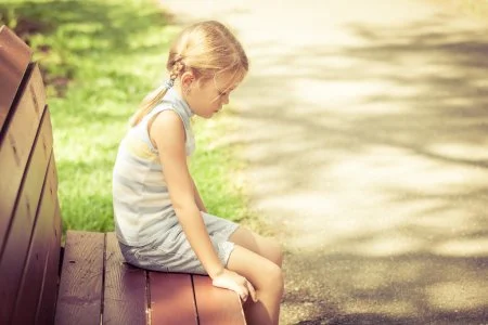 depositphotos_56393233-stock-photo-sad-little-girl-sitting-on.webp