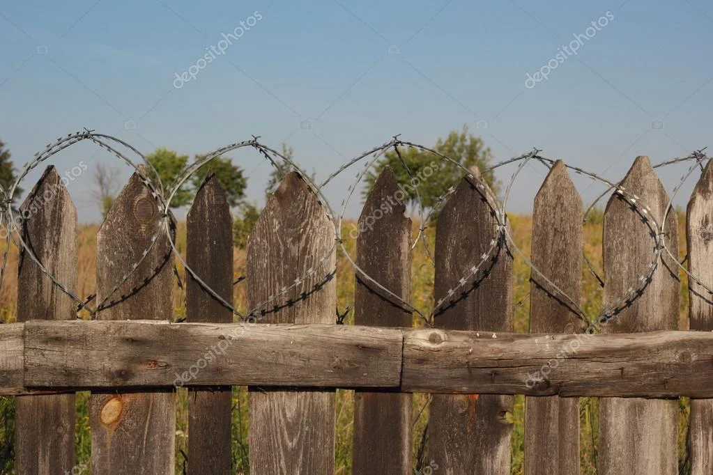 depositphotos_83428388-stock-photo-old-wooden-fence-with-barbed.webp