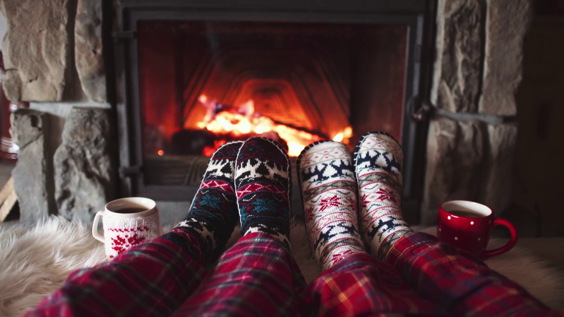 feet-in-woollen-socks-by-the-burning-christmas-cozy-fireplace-4k-couple-relaxes-by-warm-fire-w...png