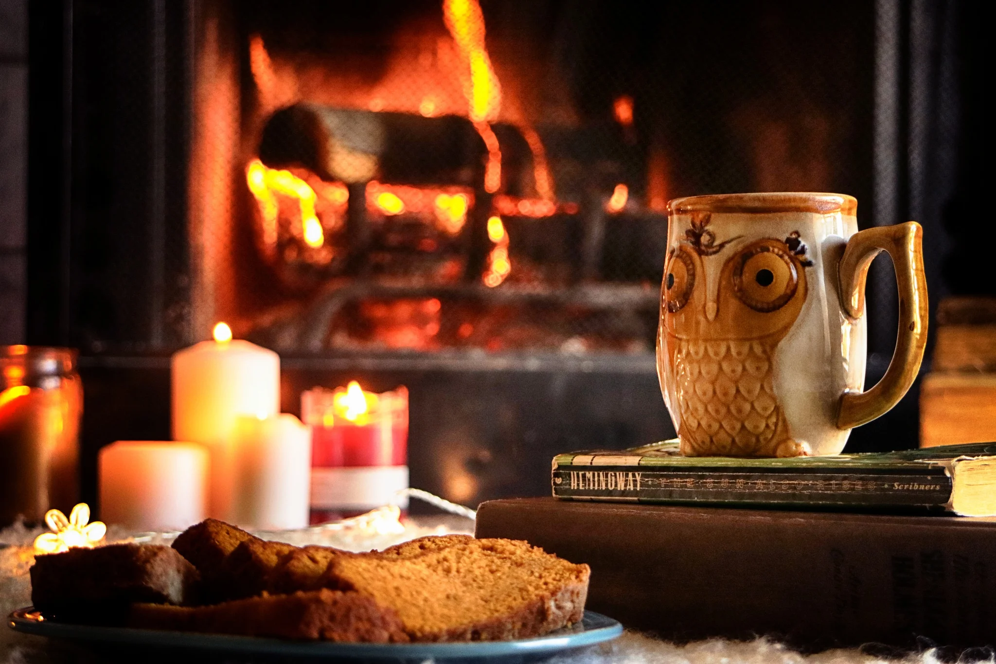 fireplace-candle-books-owl-mug-tea-bread-dessert.webp