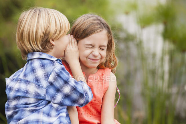 focused_181047970-stock-photo-boy-whispering-girl-ear.jpg