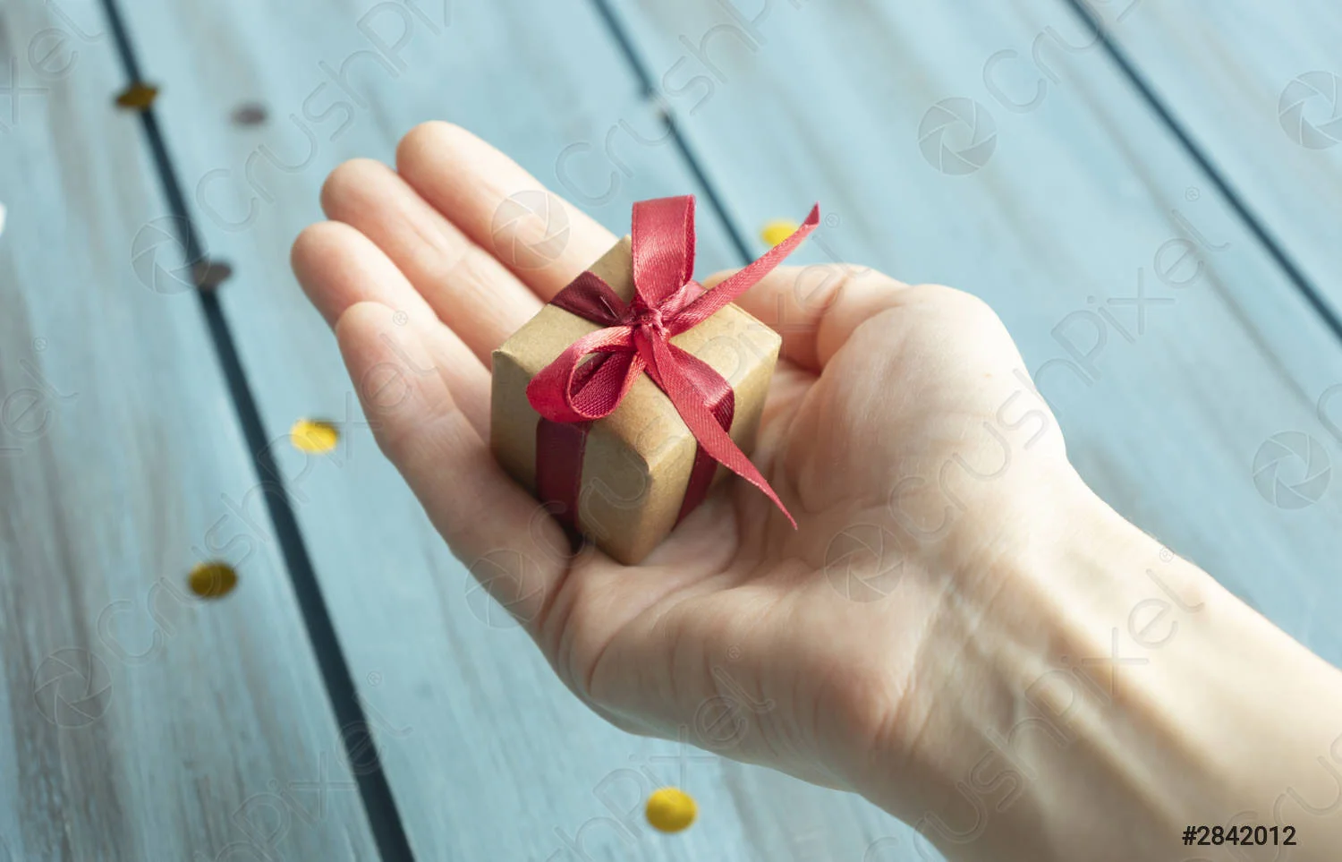 hands-holding-little-gift-with-2842012.webp