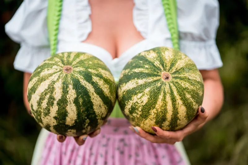 молодая-женщина-держит-два-арбуза-на-груди-и-танцует-дама-в-231491351.webp