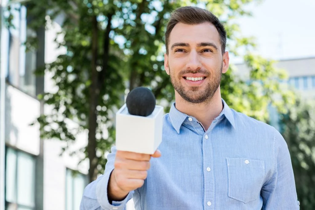 stock-photo-smiling-male-journalist-taking-interview.webp