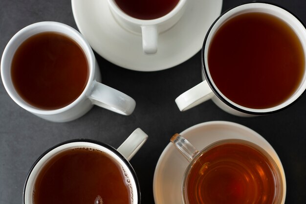 top-view-of-many-cups-mugs-with-hot-tea-drink-on-dark-copyspace-tea-time-or-tea-brake-autumn-b...jpg