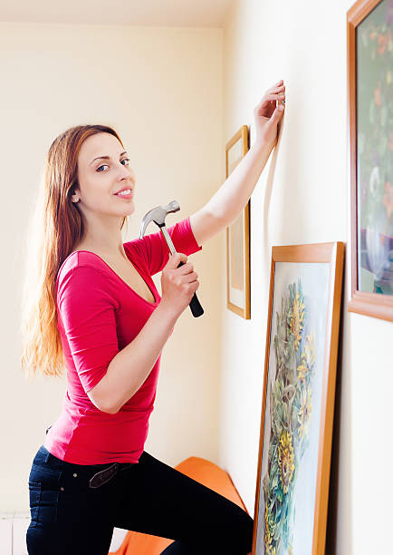 woman-hanging-the-art-pictures-on-wall.jpg