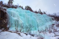 26117843-Blue-ice-and-icicles-at-a-frozen-waterfall-in-Norway-Stock-Photo.jpg